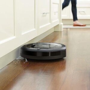 iRobot Roomba E6 Robot Vacuum on a hard floor, ideal for pet hair and dust cleaning.