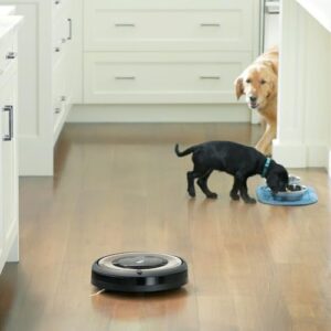 iRobot Roomba E6 Robot Vacuum on a hard floor, ideal for pet hair and dust cleaning.